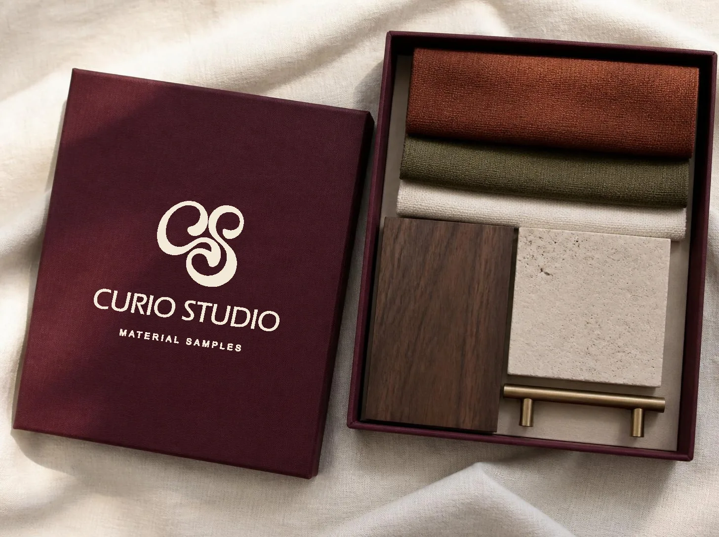 A merlot material sample box with fabric, walnut, travertine and brass samples
